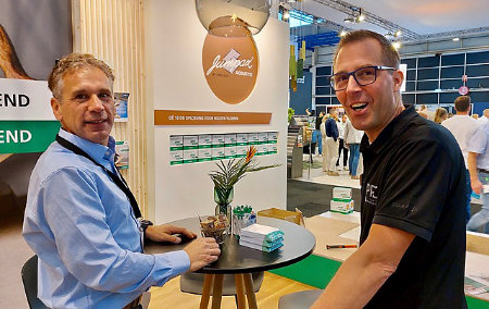 Unifloors Frank Bossers links en Niels Aarnoudse PPC praten geanimeerd bij op de stand van Unifloor