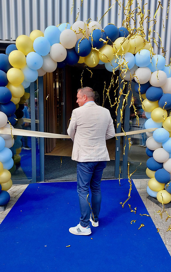 Erwin van Beek General Manager Headla m verricht de officiële handeling van het doorknippen van het lint waarmee de showroom officieel is geopend